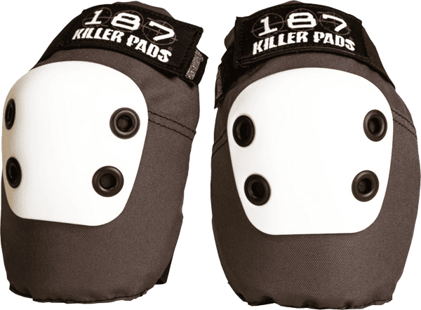 Pair of 187 Slim Elbow Pads in XS size, Dark Grey color, sitting on a flat concrete surface with a skateboard in background